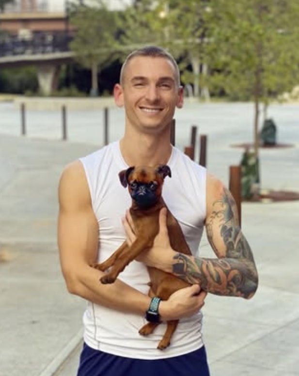 Drew J. Fisher holding Derby Floyd — canine rehabilitation and veterinary sports medicine professional based in Florida